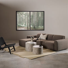 Modern living room with a brown sectional sofa, coffee table, and wall art.