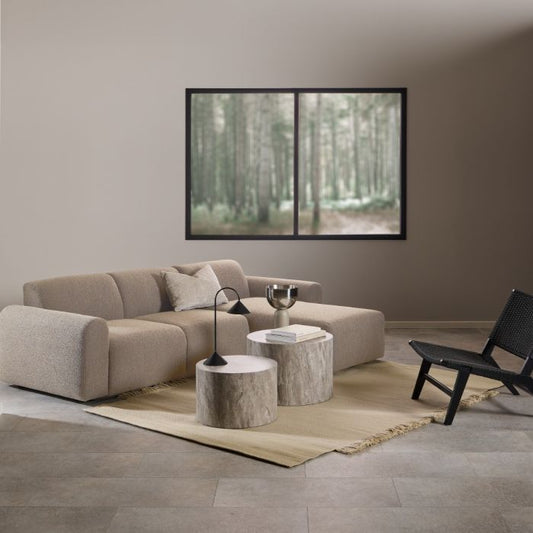 Modern living room with a beige sectional sofa, coffee table, and wall art.