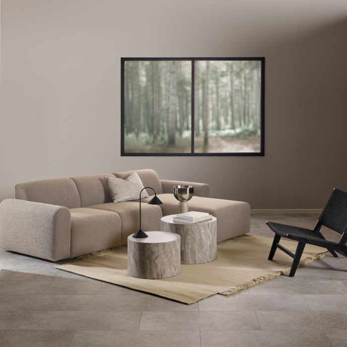 Modern living room with a beige sectional sofa, coffee table, and wall art.